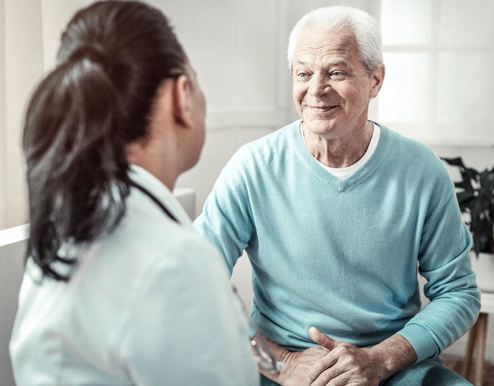 Female doctor consulting with older male patient