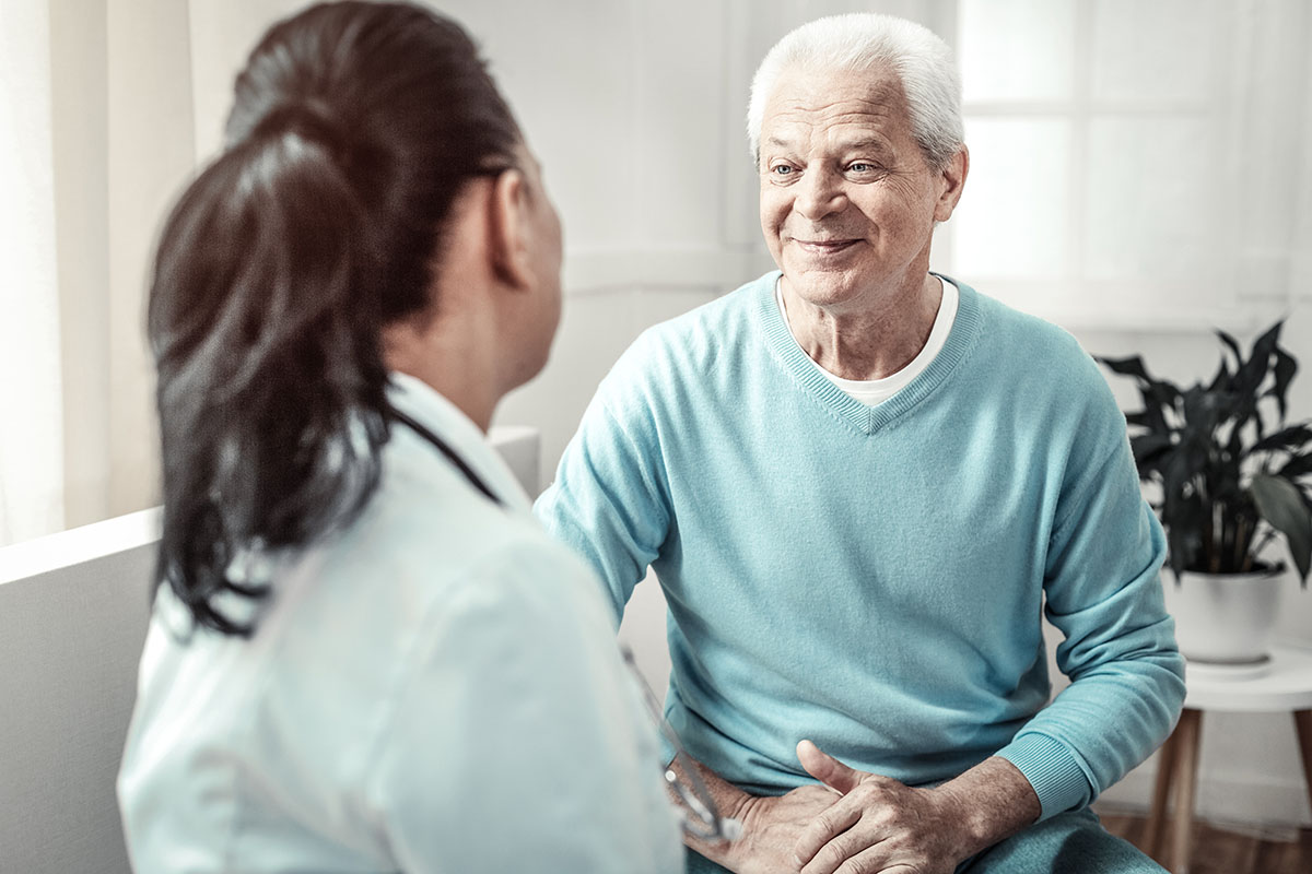 Female doctor consulting with older male patient