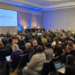 Large group of meeting attendees watching panel discussion